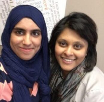 two women smile at the camera
                  