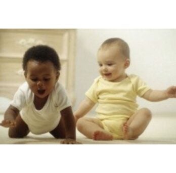 two cute babies, one is sitting, one is crawling
                  