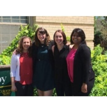 four women smile in a photo outdoors
                  