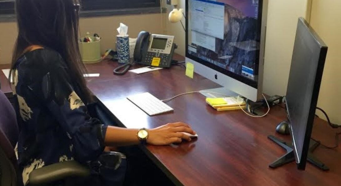 Woman sitting at desk in sunny office