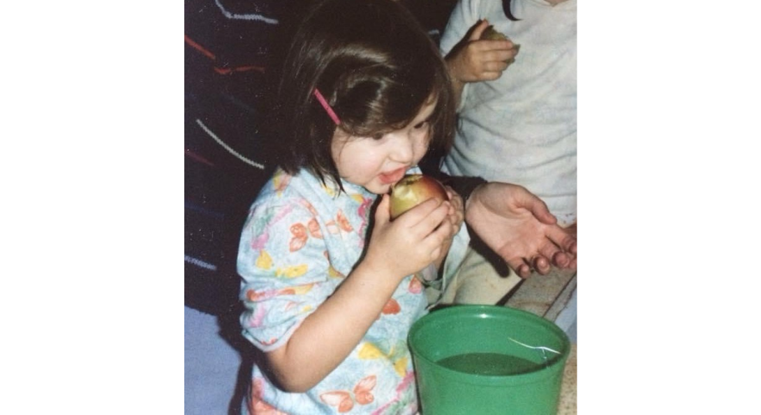 Lauren Frame as a child eating an apple.